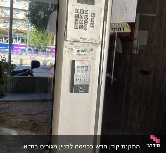 אינטרקום עם מצלמה ומקשים על קיר ליד דלת